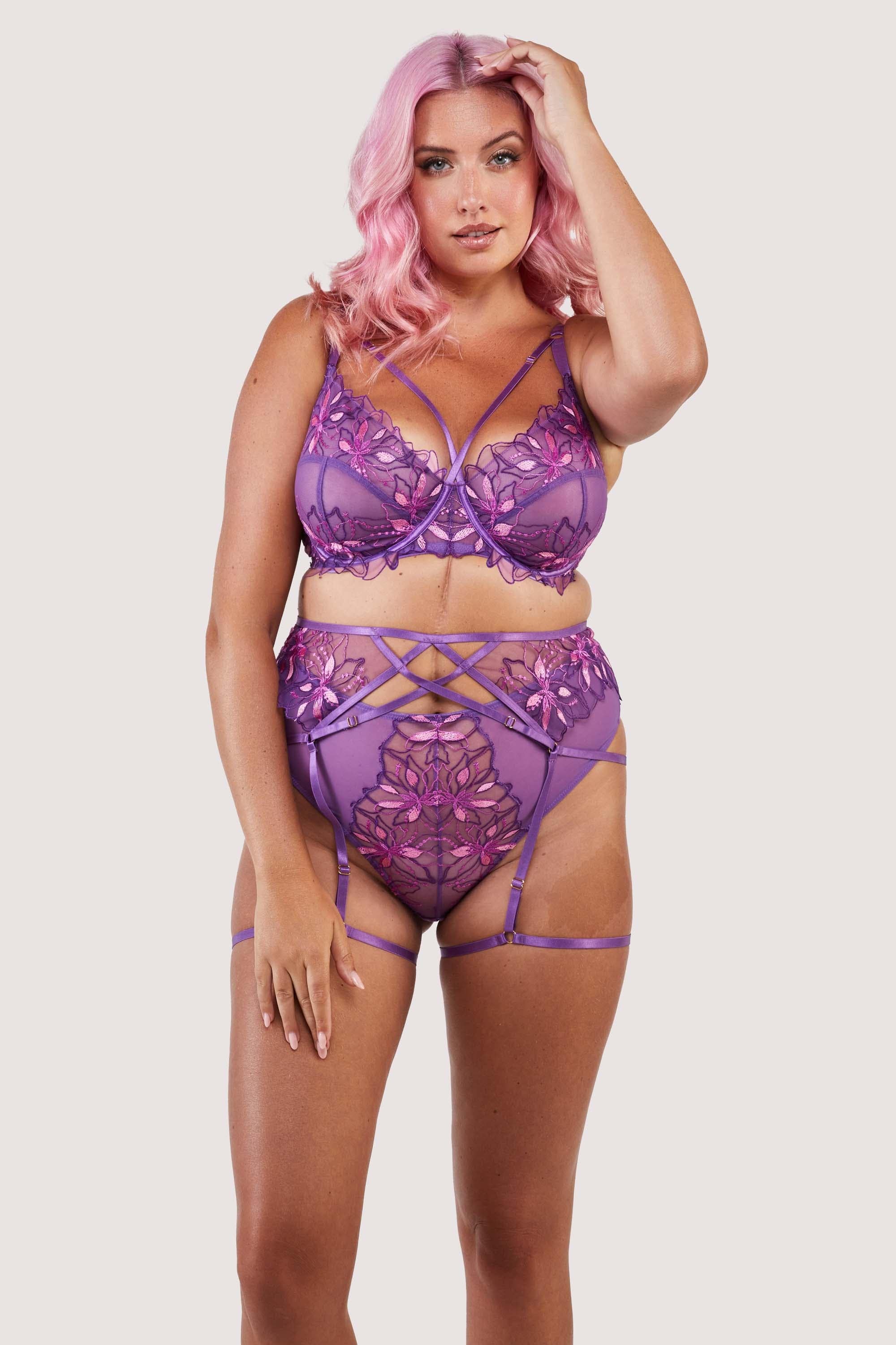 4 strap suspender with purple straps over the stomach, hips and thighs, worn with a matching bra and thong.