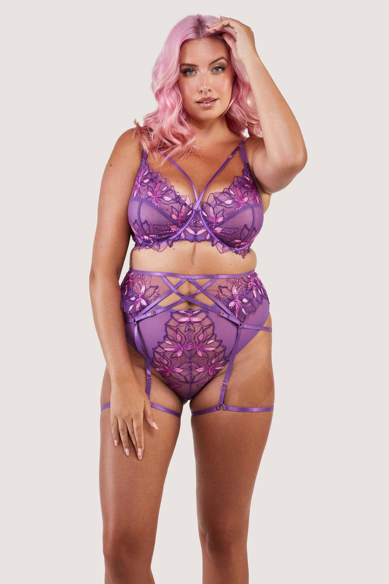 4 strap suspender with purple straps over the stomach, hips and thighs, worn with a matching bra and thong.