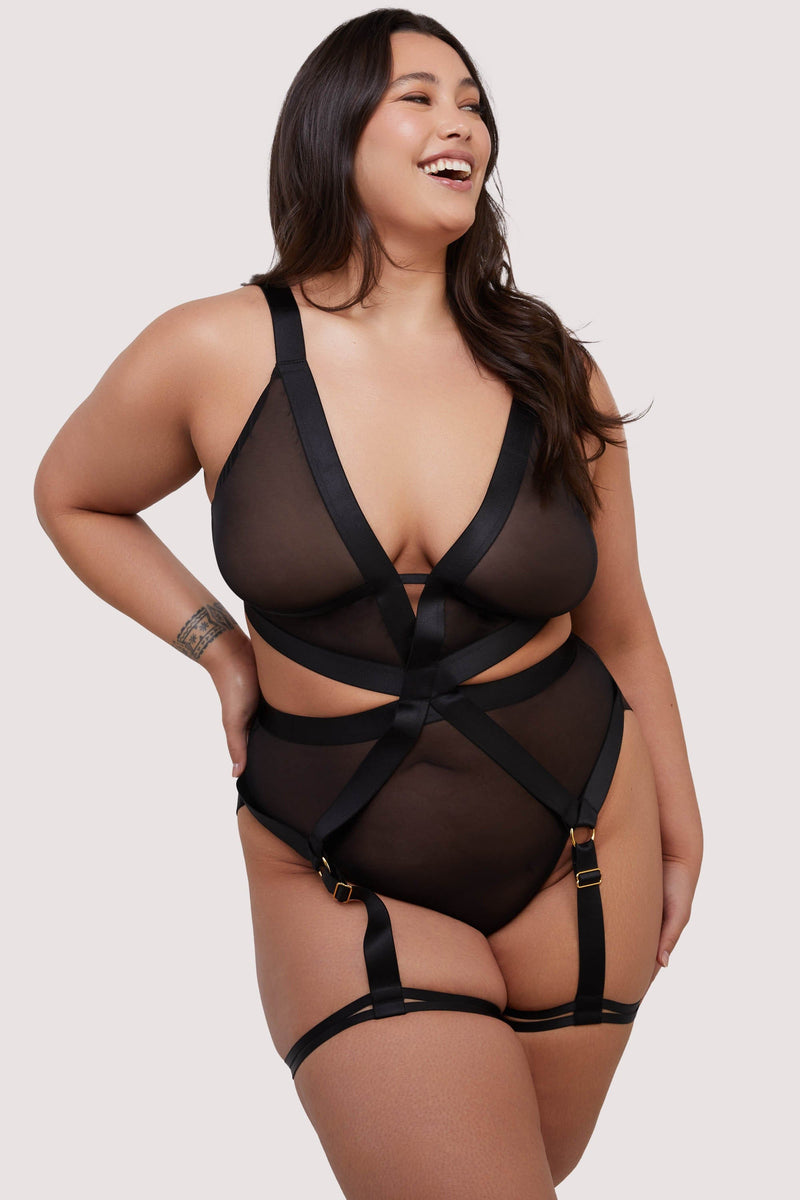 model wears black mesh elastic multi strap bodysuit