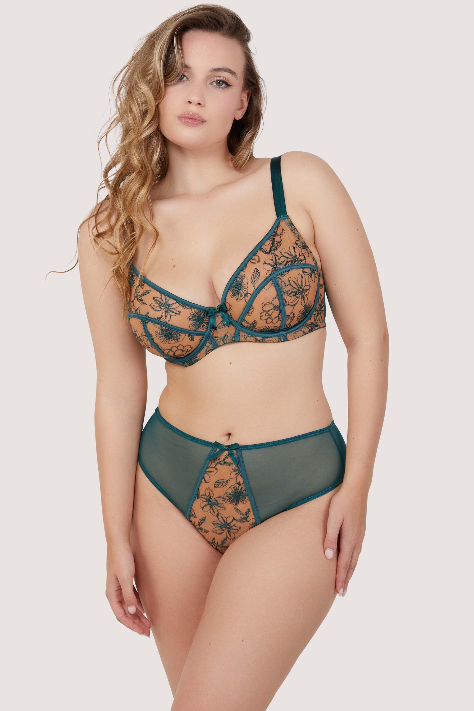 Fuller Bust Model wears a teal contrast embroidery balconette bra and high waisted brief set featuring nude mesh and teal floral detailing