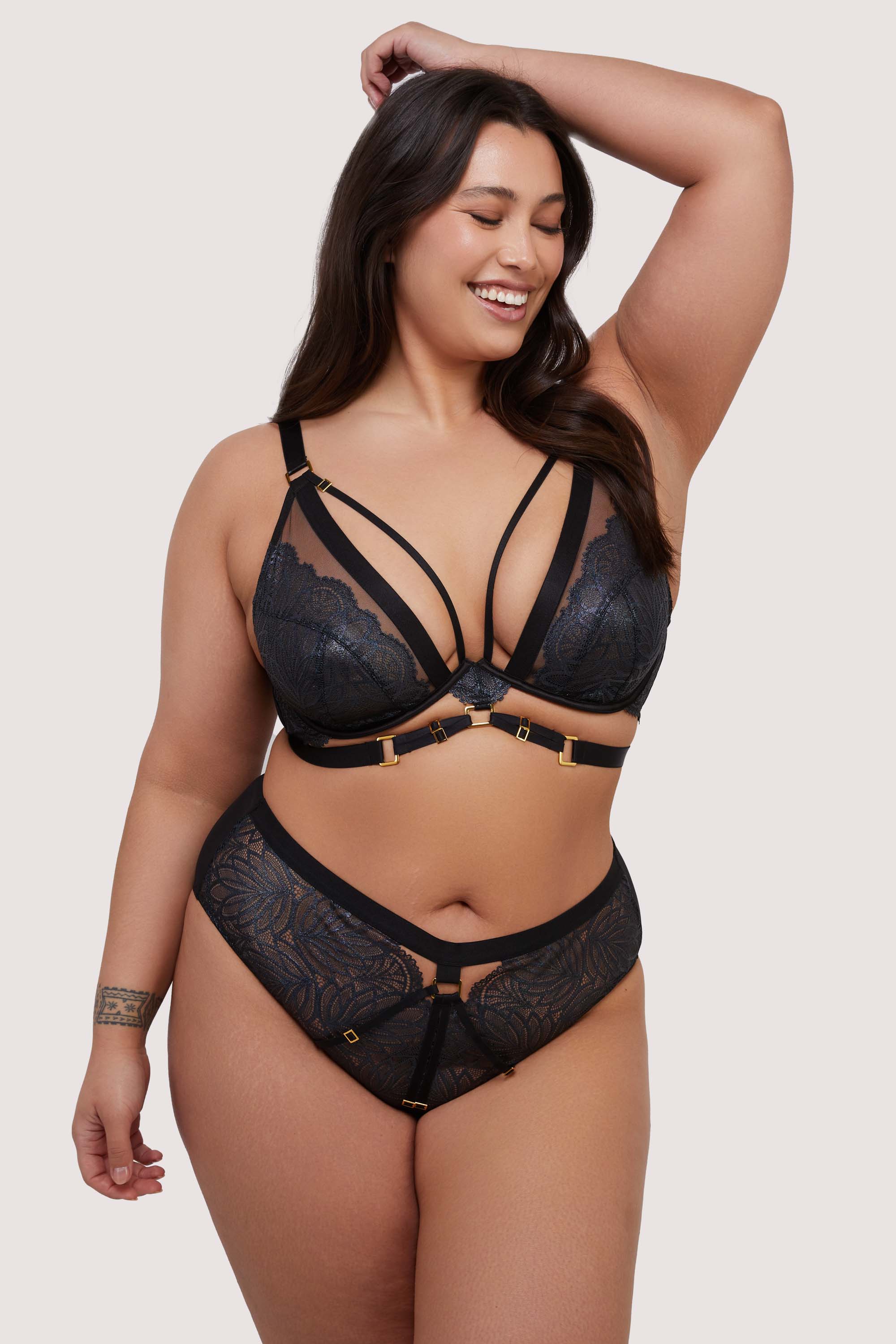 model wears black plunge bra and brief lingerie set with straps