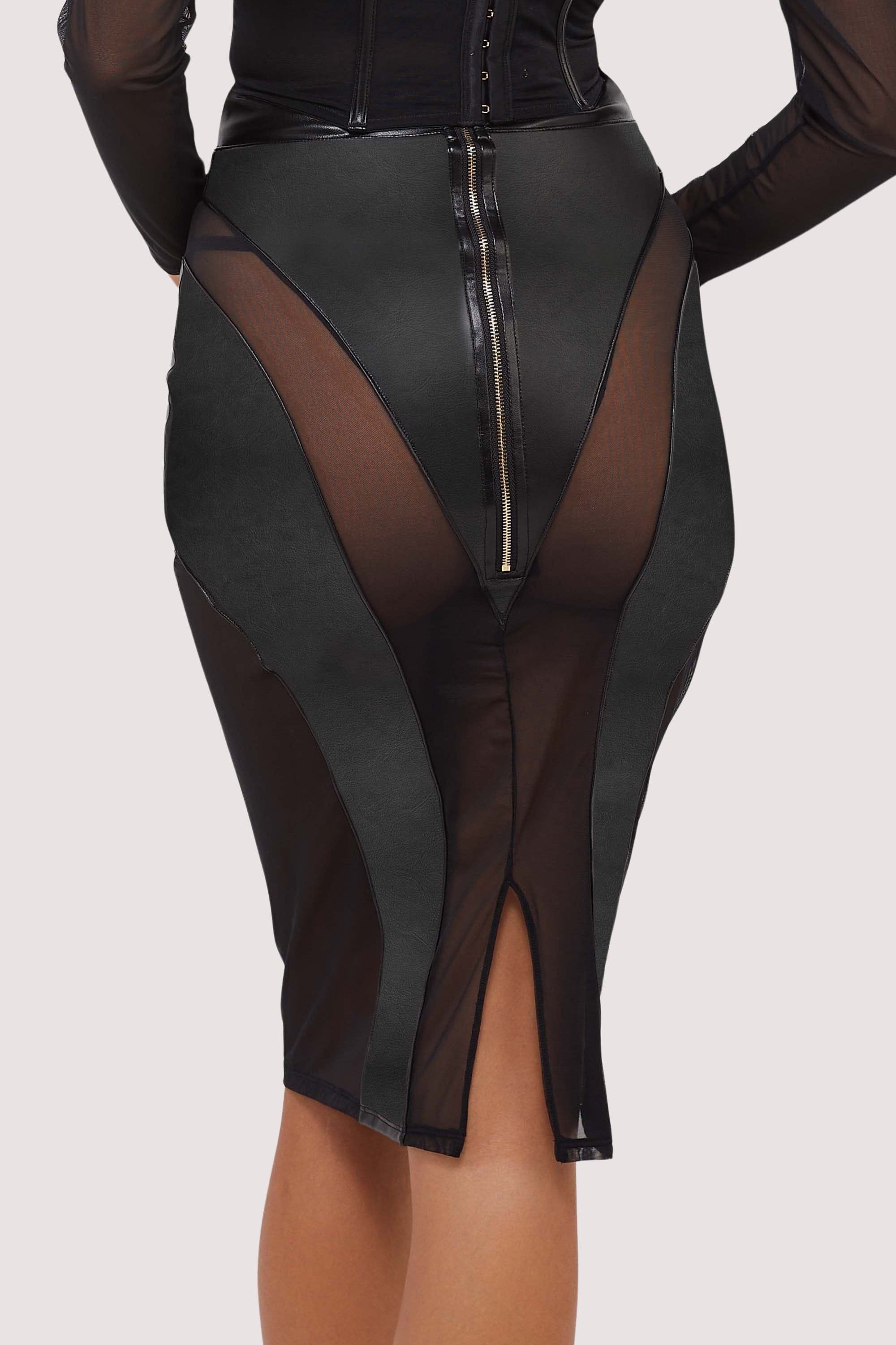 Model wears a black vegan leather mesh insert pencil skirt featuring leather panels with sheer mesh inserts with waist cinching, silhouette defining fit.