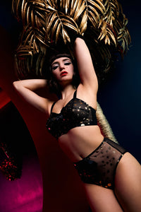 model wears Solar black and gold cosmic print high waist brief with Solar black and gold cosmic bullet bra